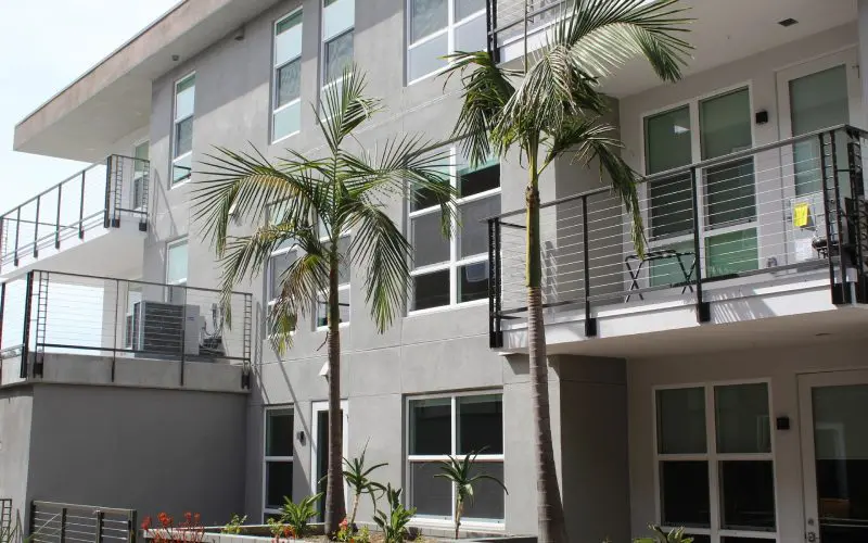 A building with palm trees in front of it.