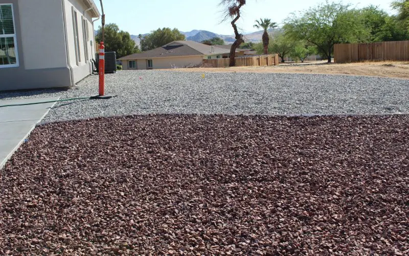 A gravel driveway with a fire hydrant in the middle of it.