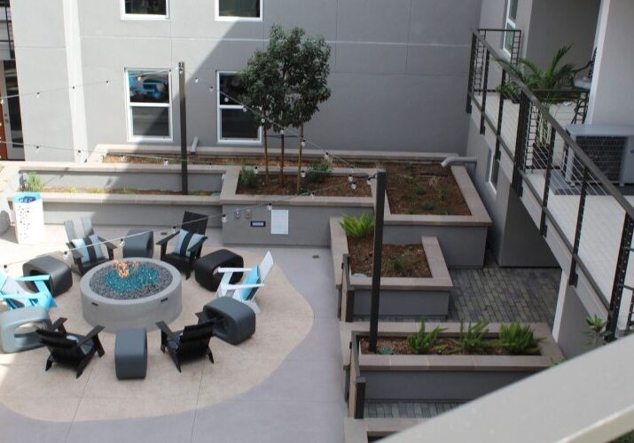 A patio with chairs, tables and fire pit.